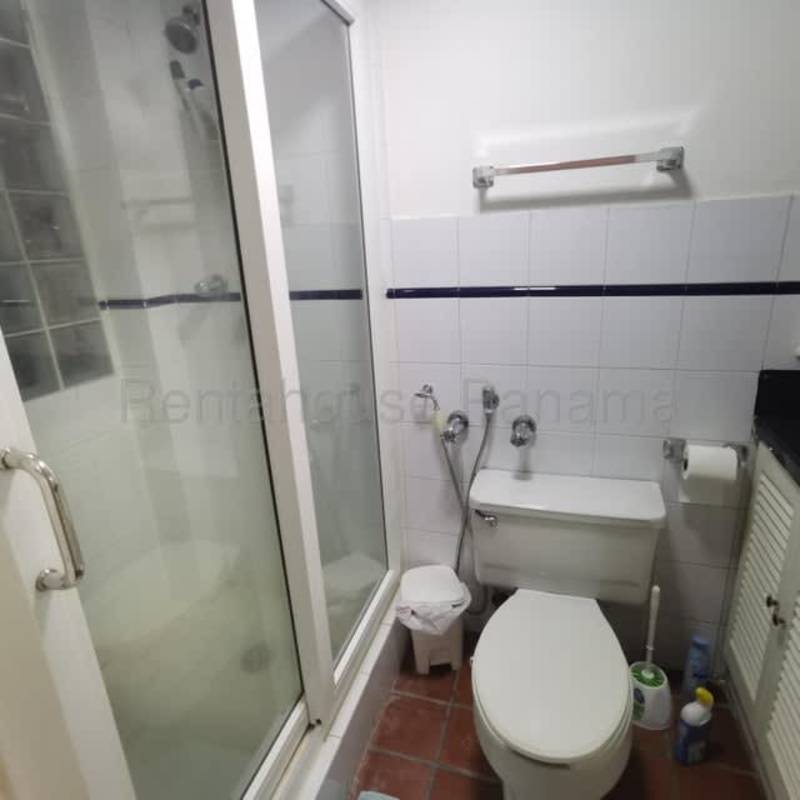 Small bathroom with white tile, glass shower Casco Viejo apartment Panama