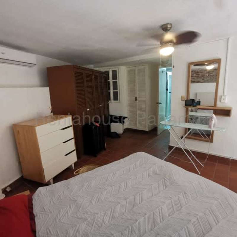 Bedroom with brick wall and ceiling fan Casco Viejo apartment Panama