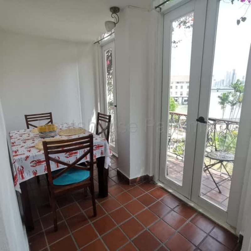Dining room with balcony overlooking city and bay Casco Viejo apartment Panama