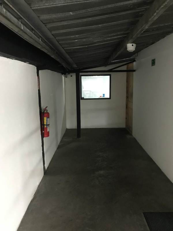 View into garage workshop with shutter open parked truck tires stacked inside commercial property Parque Lefevre Panama