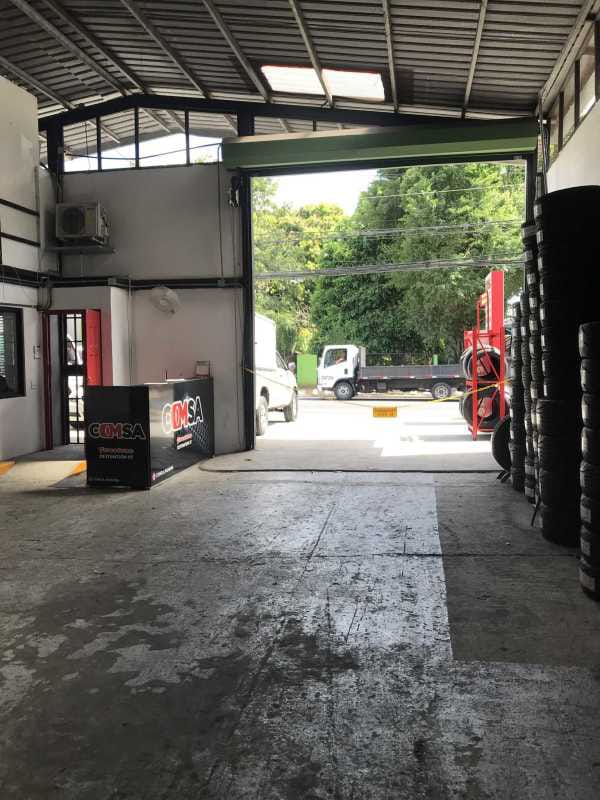 Open workshop space with stacked tires and loading shutter door Parque Lefevre Panama