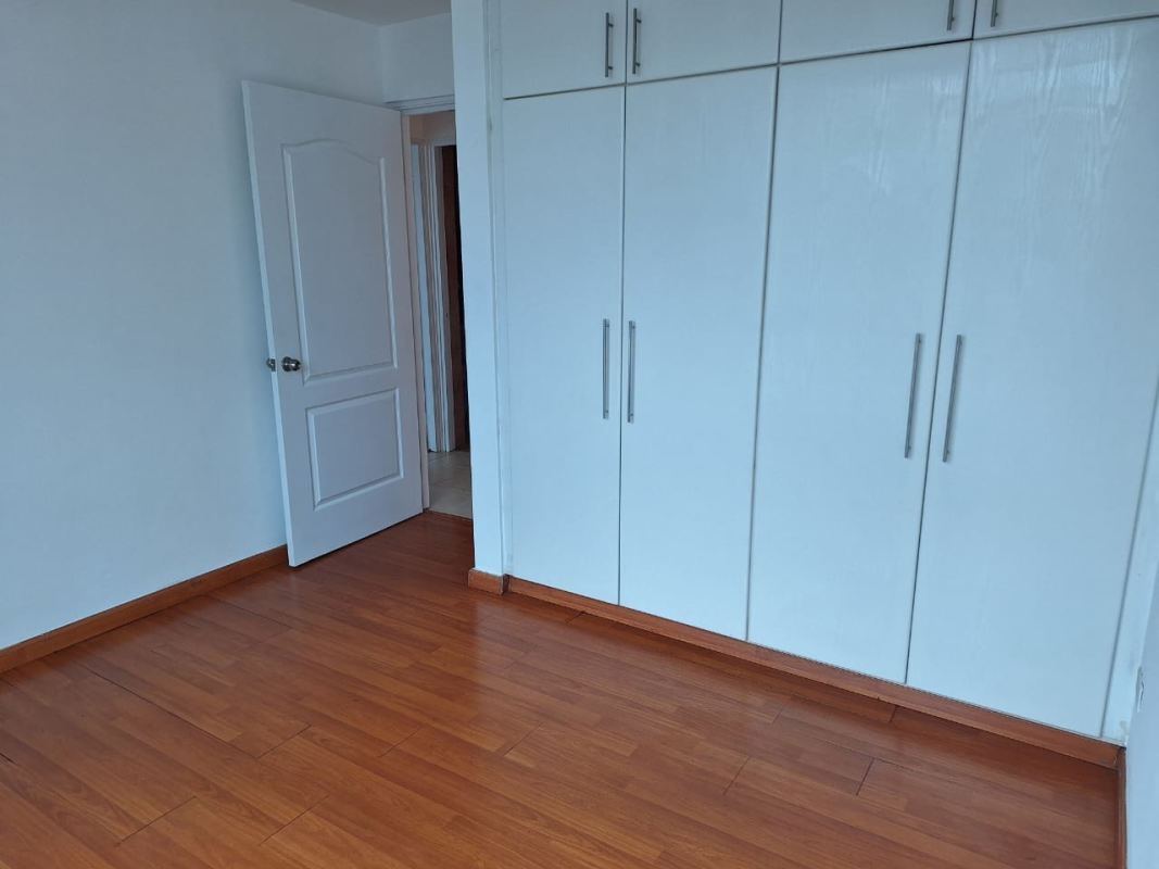 Bedroom with window AC and wood flooring Panama City apartment rent