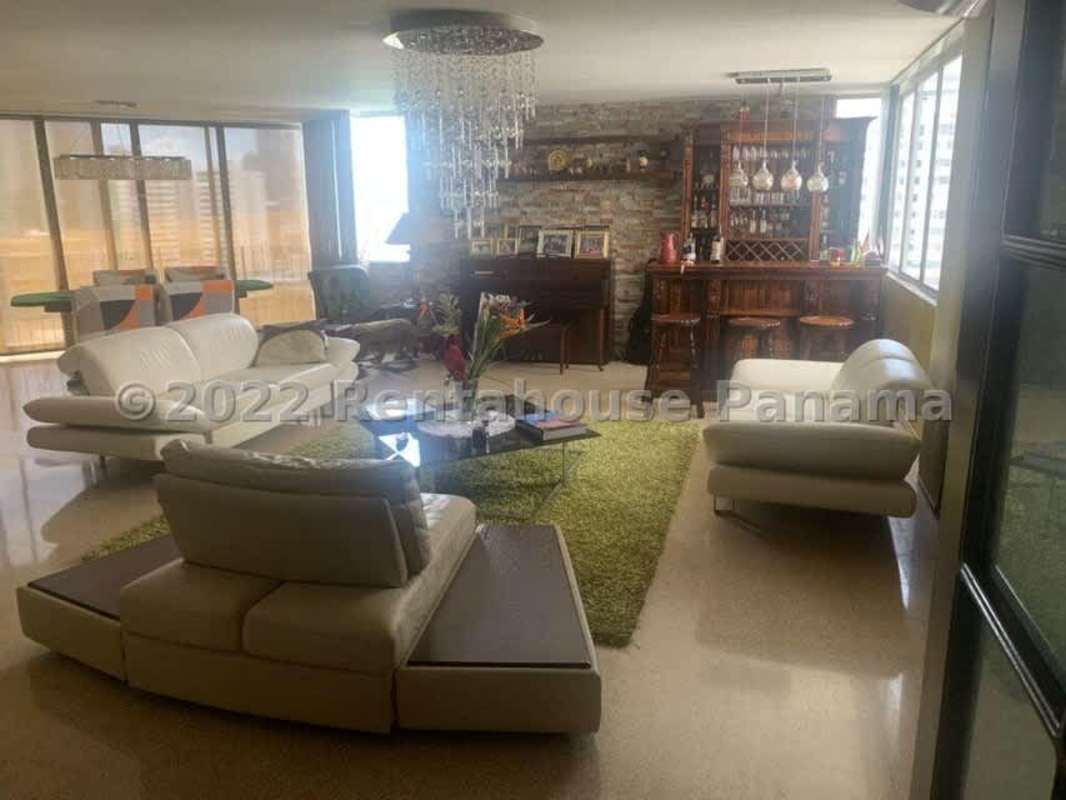 Traditional dining room with chandelier, large table and dark wood cabinetry in Punta Paitilla rental