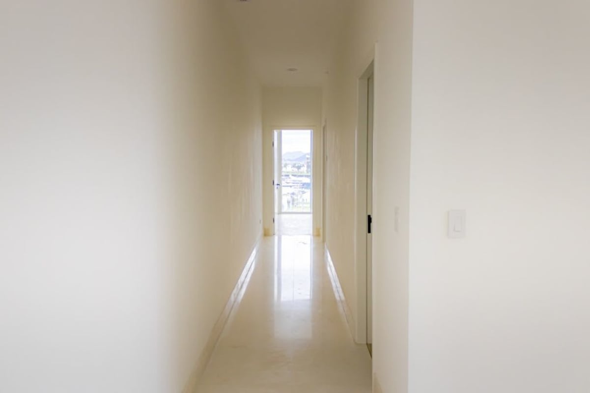Small bright minimalist room with white walls single window light floors at Ocean Reef Islands Panama
