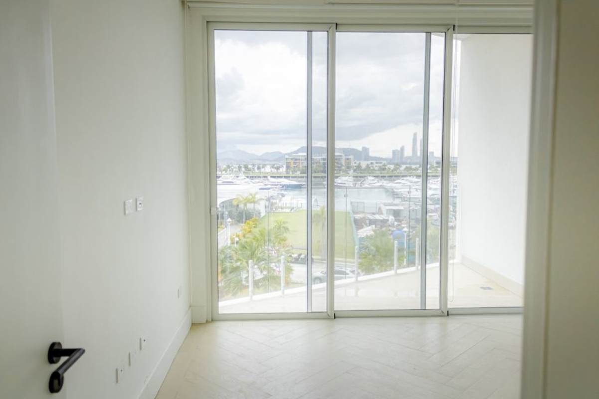 Room with herringbone floor large glass doors marina city skyline Panama Ocean Reef Islands