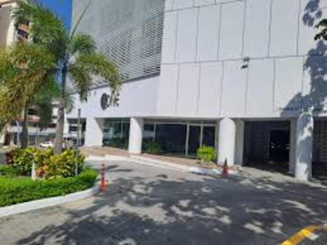 Modern glass facade building with driveway and greenery PH Tee One San Francisco Panama