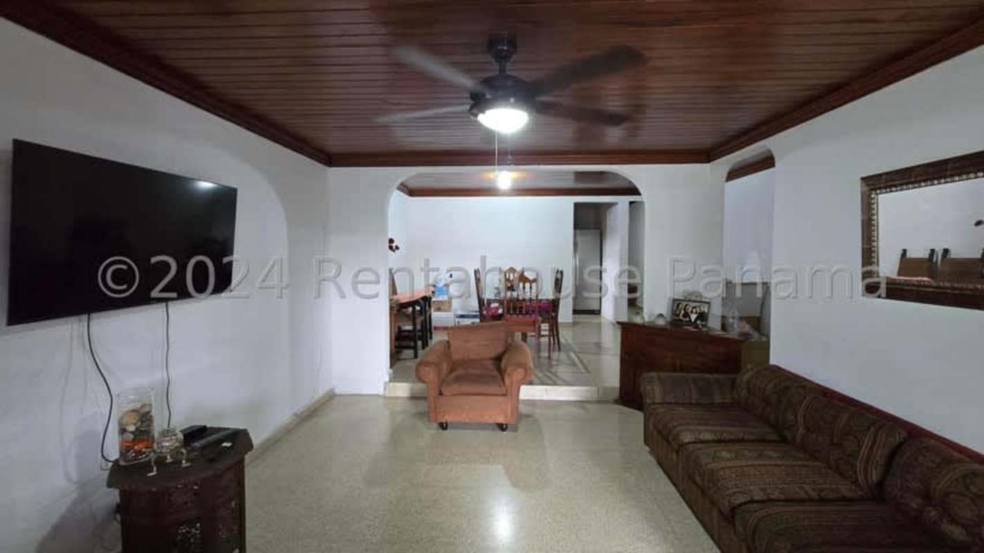 Large backyard with trees and concrete walkway in Betania house Panama City