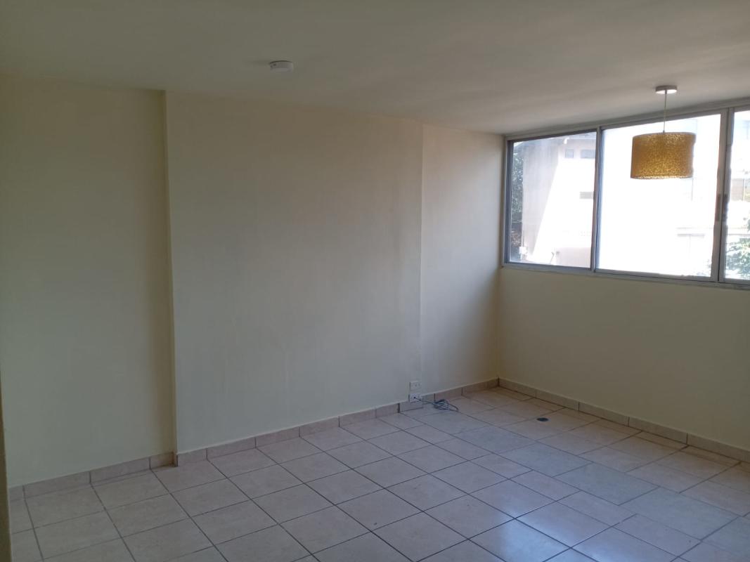 Open living room with large window neutral paint and tile floor for sale PH Las Lomas Panama