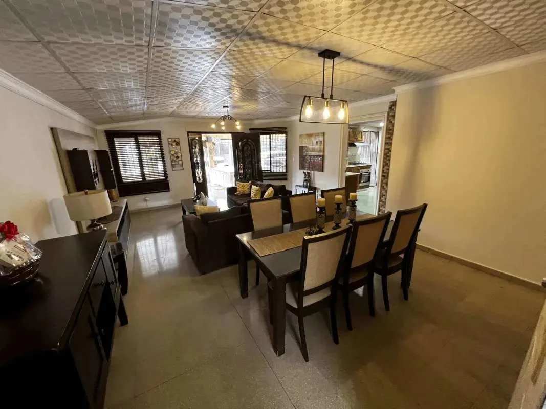 Spacious living dining area furnished with sectional sofas and dining set Villa Lucre Panama