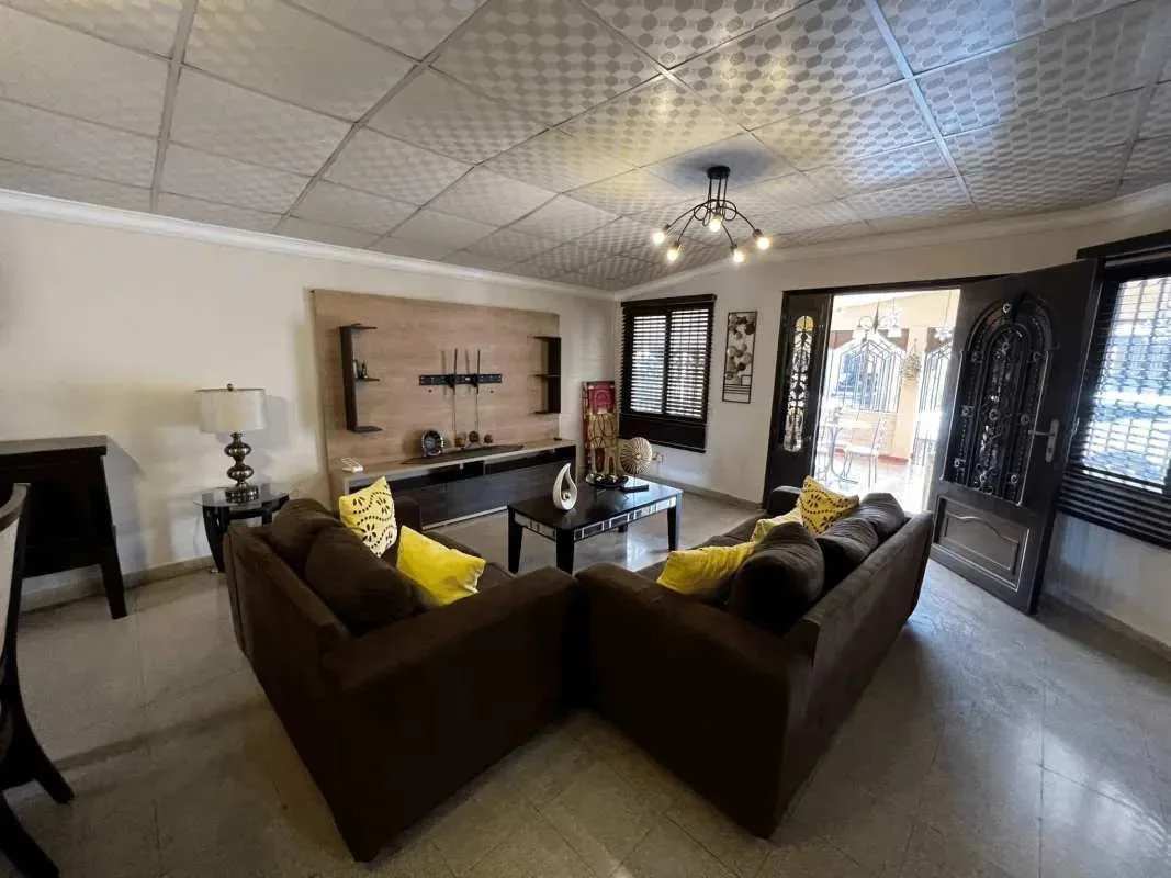 Living room area with sectional sofa, large window, entertainment center Villa Lucre Panama