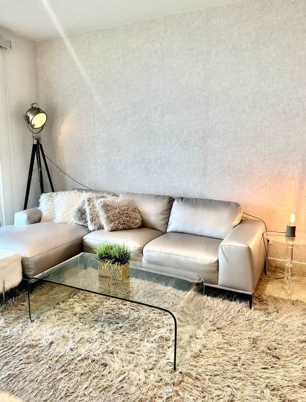 Bright living room with large sectional sofa, glass coffee table, and stylish furnishings at Yoo Panama Panama City