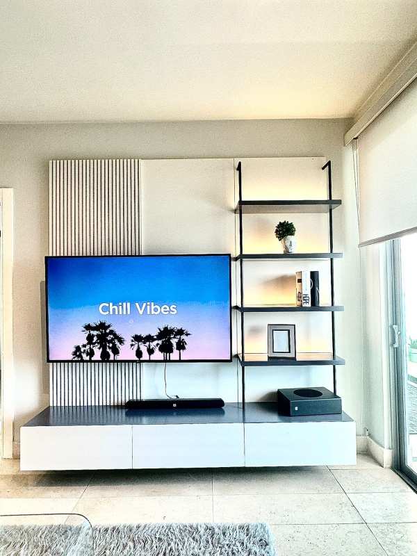 Modern entertainment unit with wall-mounted TV, storage, and decor Yoo Panama Avenida Balboa