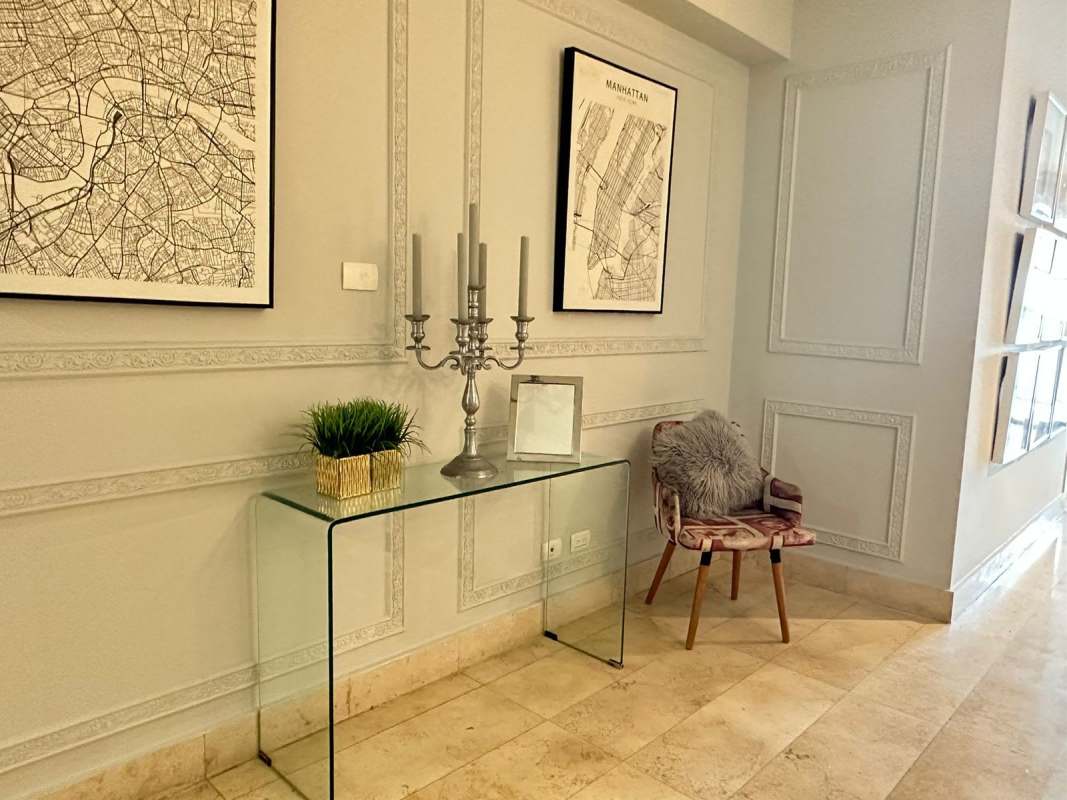 Elegant hallway with marble floors, wall molding, console table, and designer decor at Yoo Panama Avenida Balboa