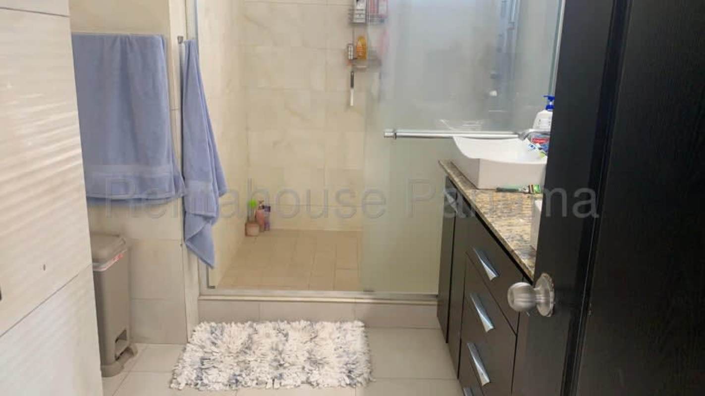 Contemporary bathroom with granite countertop and glass shower in luxury Panama apartment