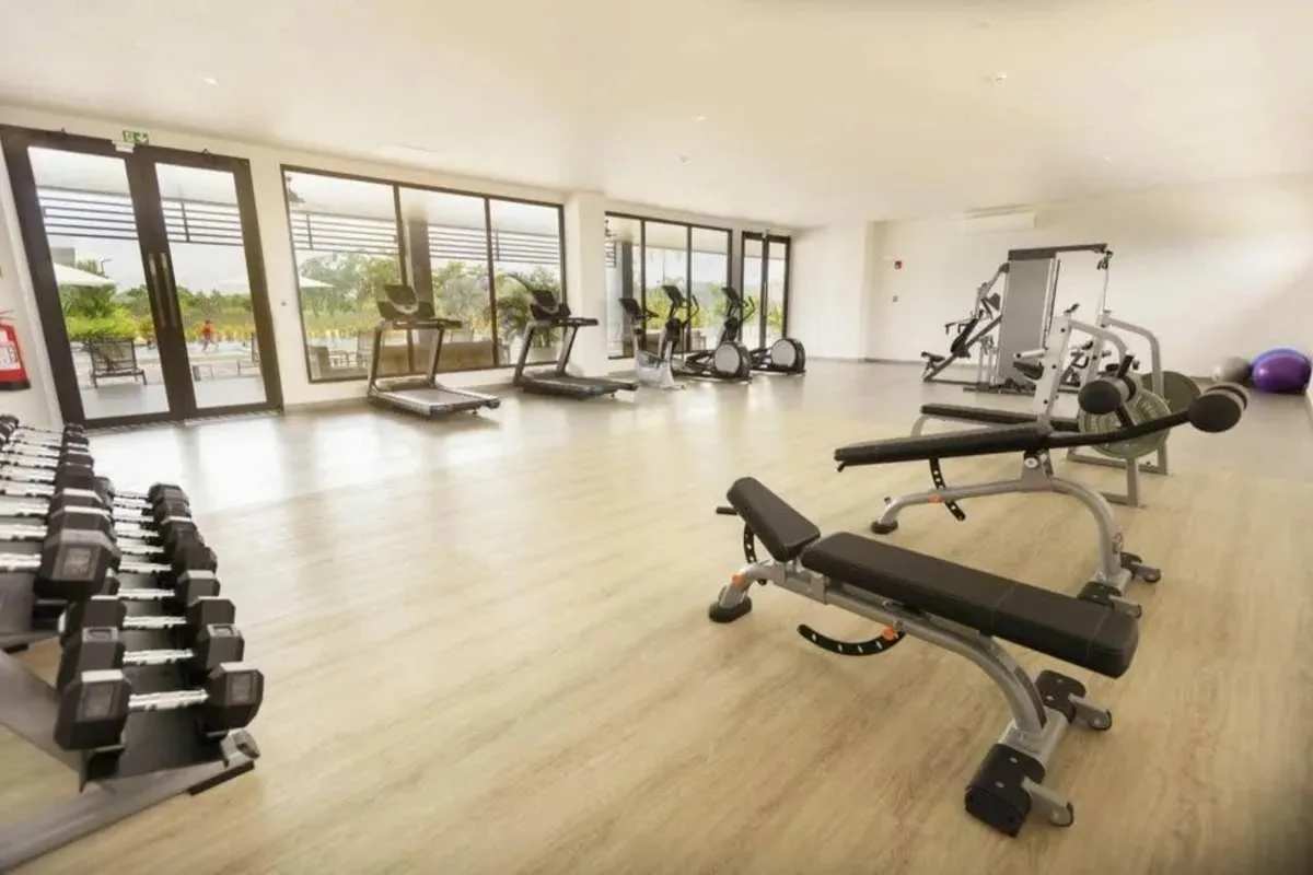 Modern gym with cardio machines, weights, and floor-to-ceiling windows in PH Victoria Brisas del Golf Panama