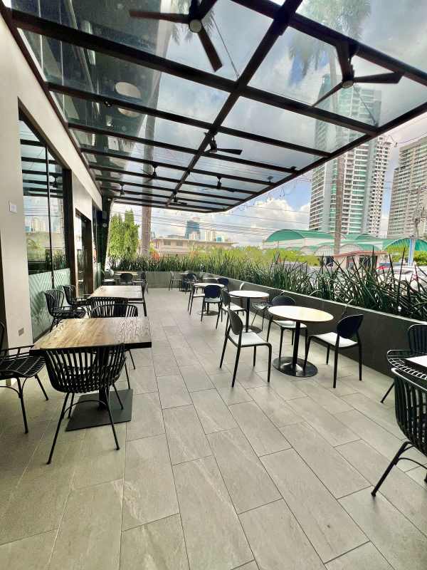 Modern outdoor patio seating area with glass canopy ideal for restaurant in San Francisco Panama