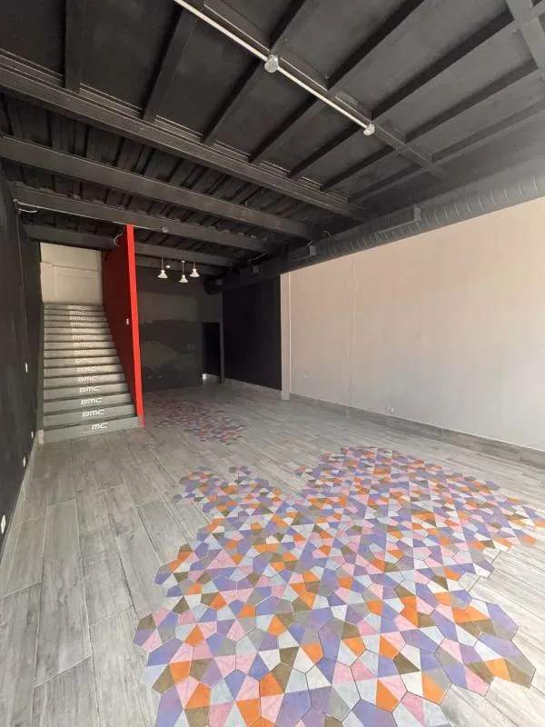Open industrial commercial space with colorful geometric floor tiles, black ceiling, Plaza SF69 Panama