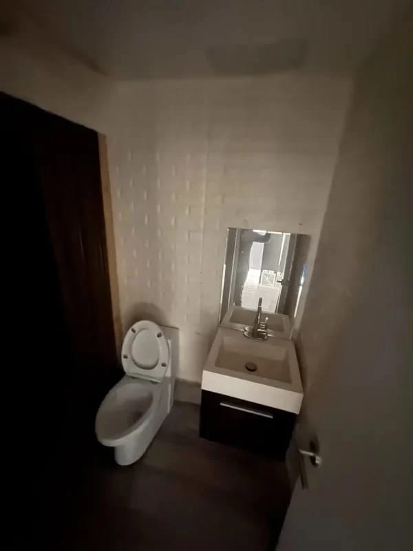 Small minimalist bathroom with textured white wall, toilet and sink at Plaza SF69 San Francisco Panama