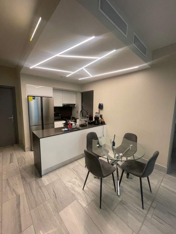 Open kitchen with dining area, stainless steel appliances and stylish lights in PH Armani Panama City