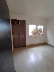 Empty spacious bedroom with tile floor built-in wardrobe window in beach house Panama