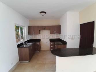 Modern kitchen with granite counters dark cabinets bright window beach home Panama