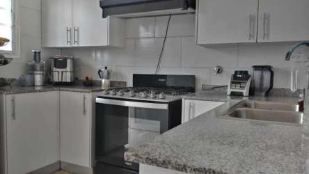 Kitchen with granite countertops, cabinets, and stove in house Vista Verde Panama