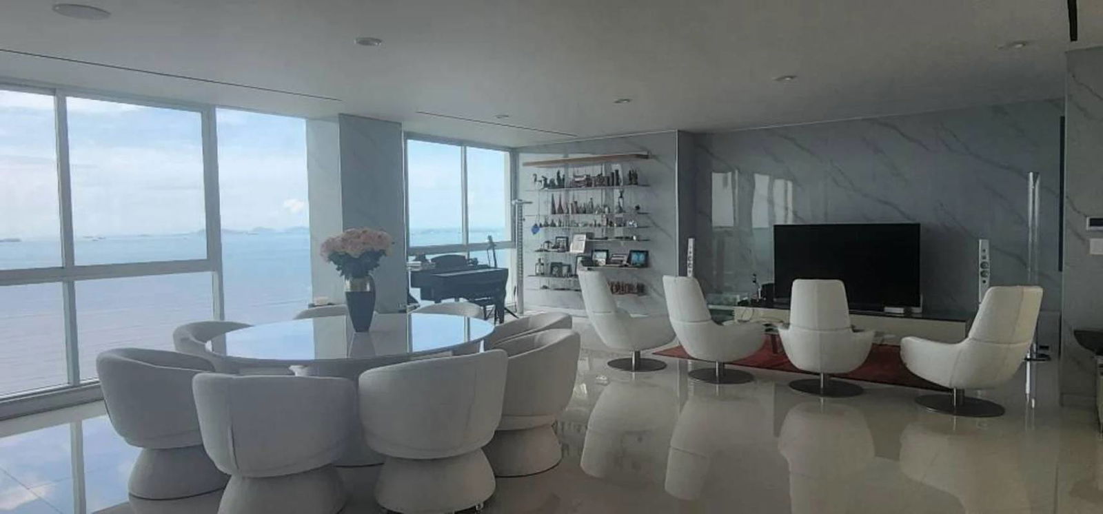 Bright modern living room with workspace, panoramic ocean views, marble walls and balcony in The Regent Costa del Este Panama