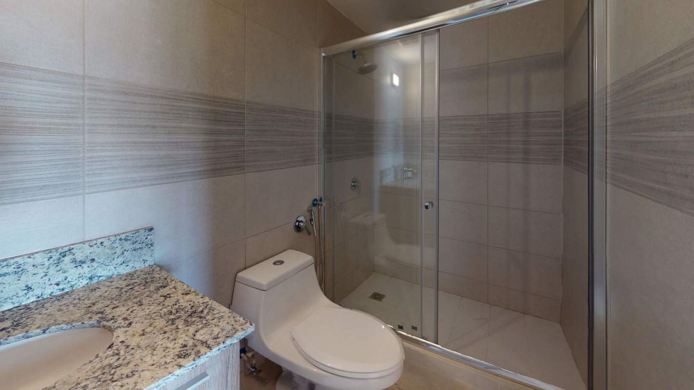 Modern bathroom with glass shower and marble counter at PH Greenwood Towers
