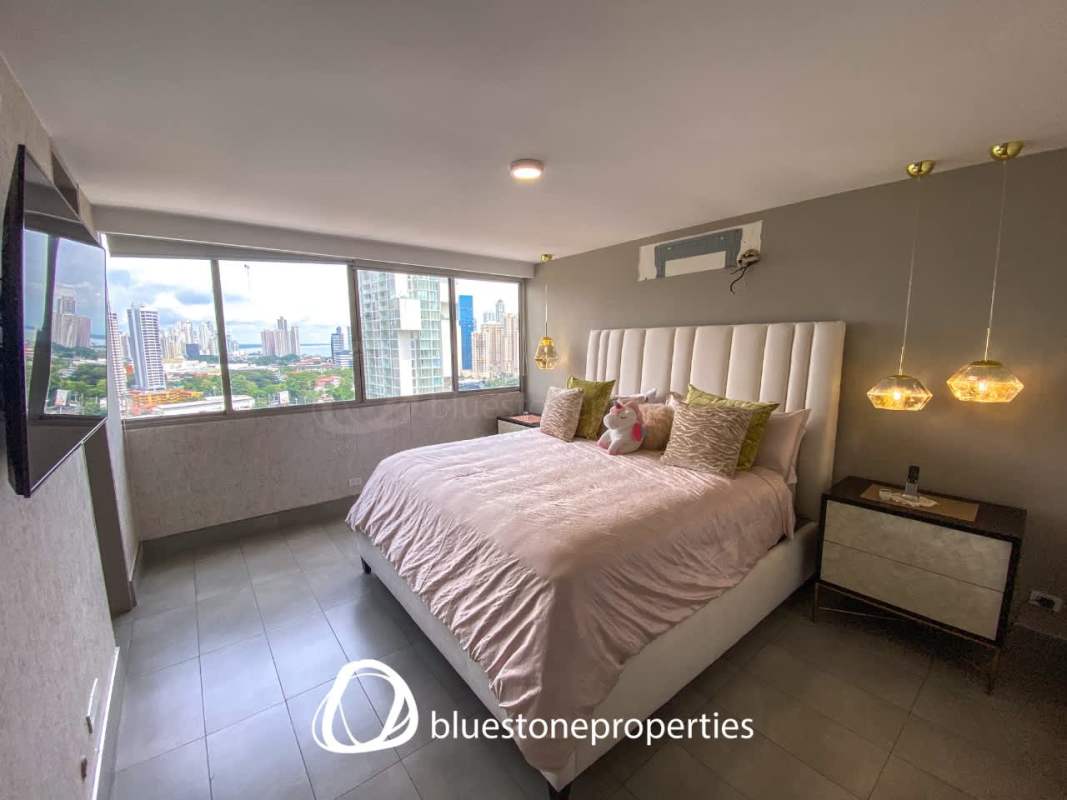 Modern bedroom with large windows, city skyline view at PH Marriott Marbella Panama