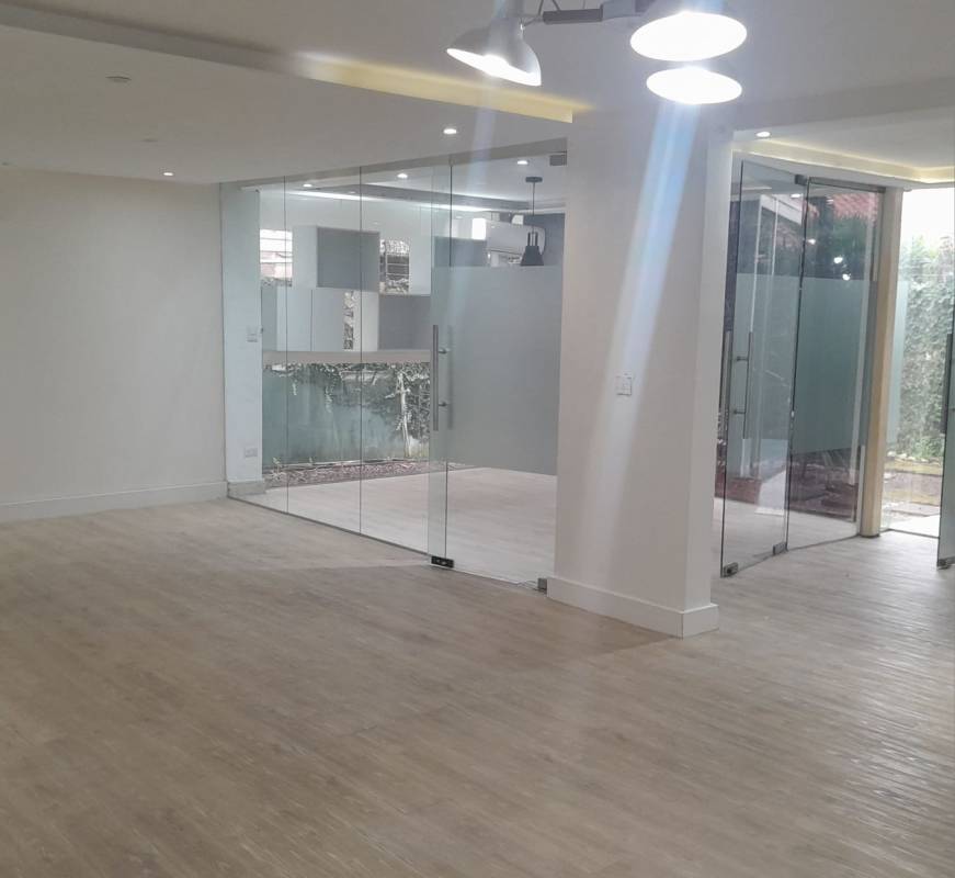 Open office layout with glass partitions wood flooring recessed lights in San Francisco Panama