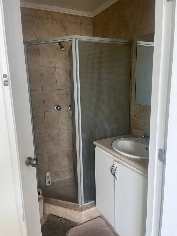Modern bathroom with glass shower enclosure and tiled walls for rent in PH Green Park Condado del Rey Panama