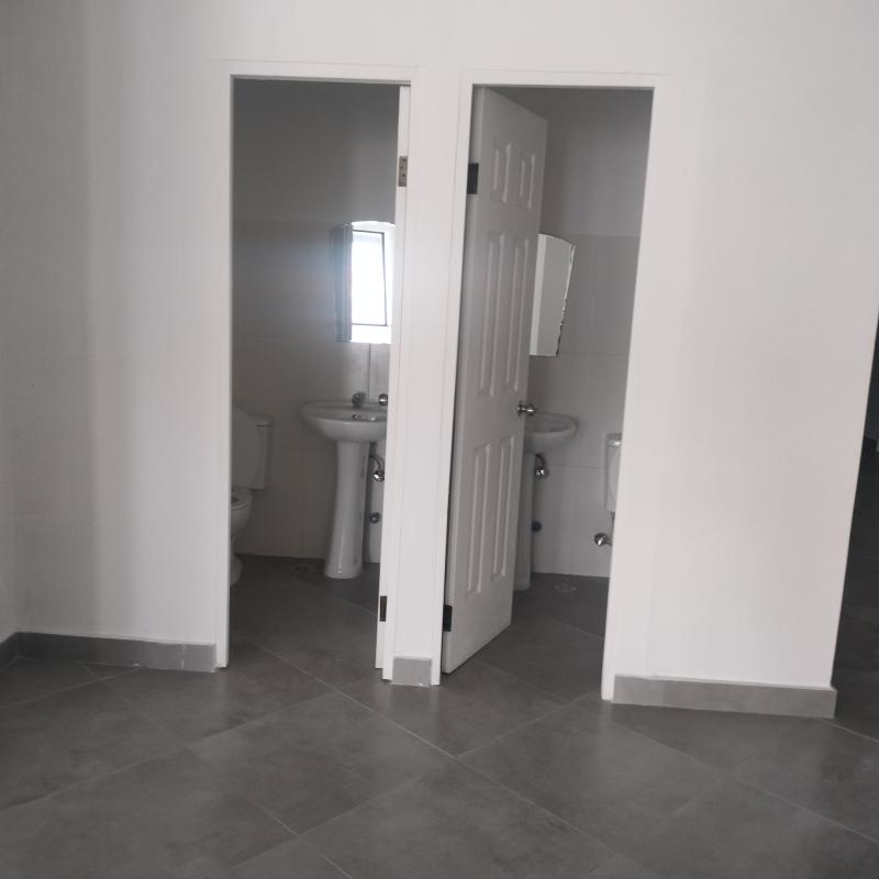 Open interior of brand new commercial space with tiled floors and white columns in Panama