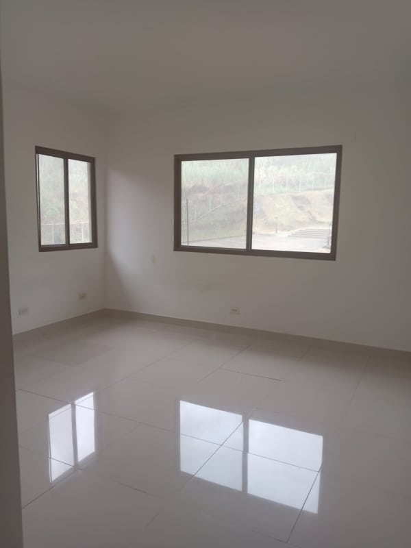 Empty bedroom with large windows, glossy tile floor and garden views in Brisas del Golf San Miguelito
