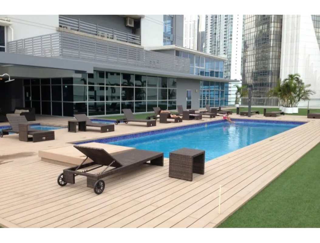 Building rooftop swimming pool with sun loungers against city skyline Colores de Bellavista Panama