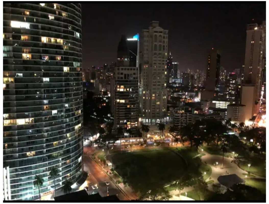 Panoramic night view of Panama City skyline with illuminated towers from PH Colores de Bellavista