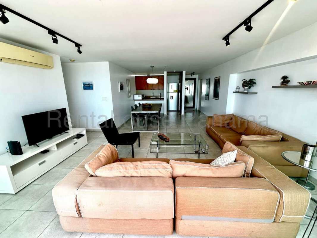 Modern living room with glass doors opening to balcony and Pacific ocean view at PH Terrawind San Francisco Panama