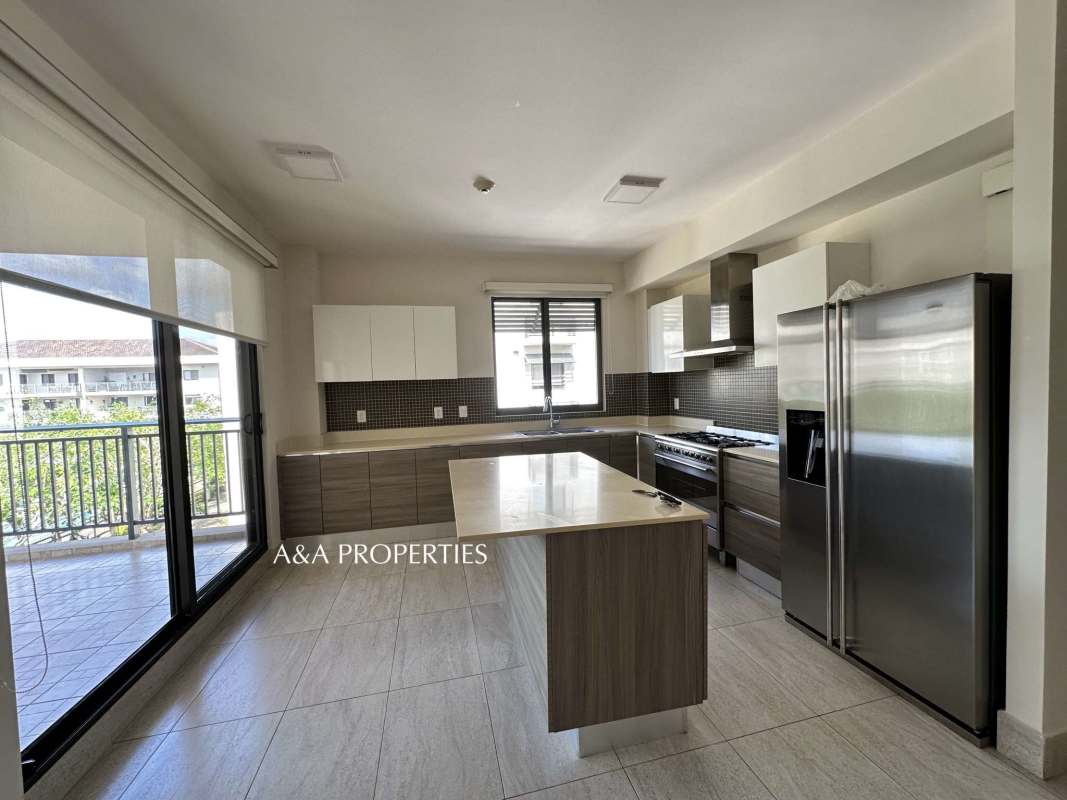 Modern kitchen with island, white cabinetry and appliances in River Valley Panama Pacifico apartment