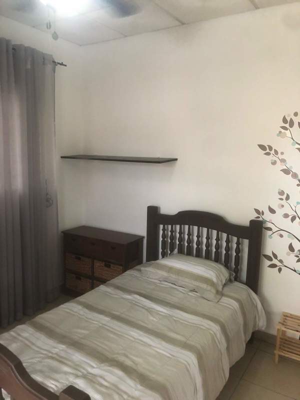 Private student bedroom with single bed, closet and wall decal at Villa Cáceres Panama