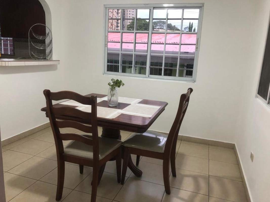 Dining table with chairs next to window in affordable rental Villa Cáceres Panama City