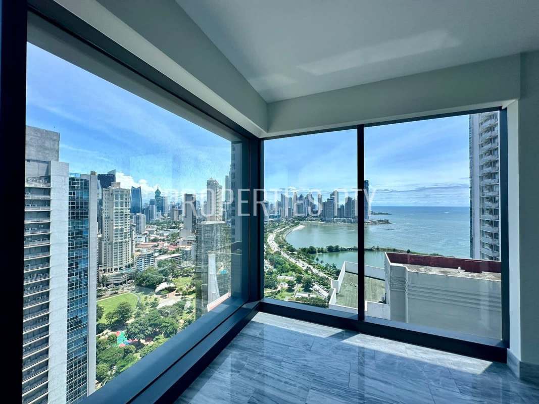 Modern living area with large windows, marble flooring, city skyline view at Nuovo by Armani on Avenida Balboa