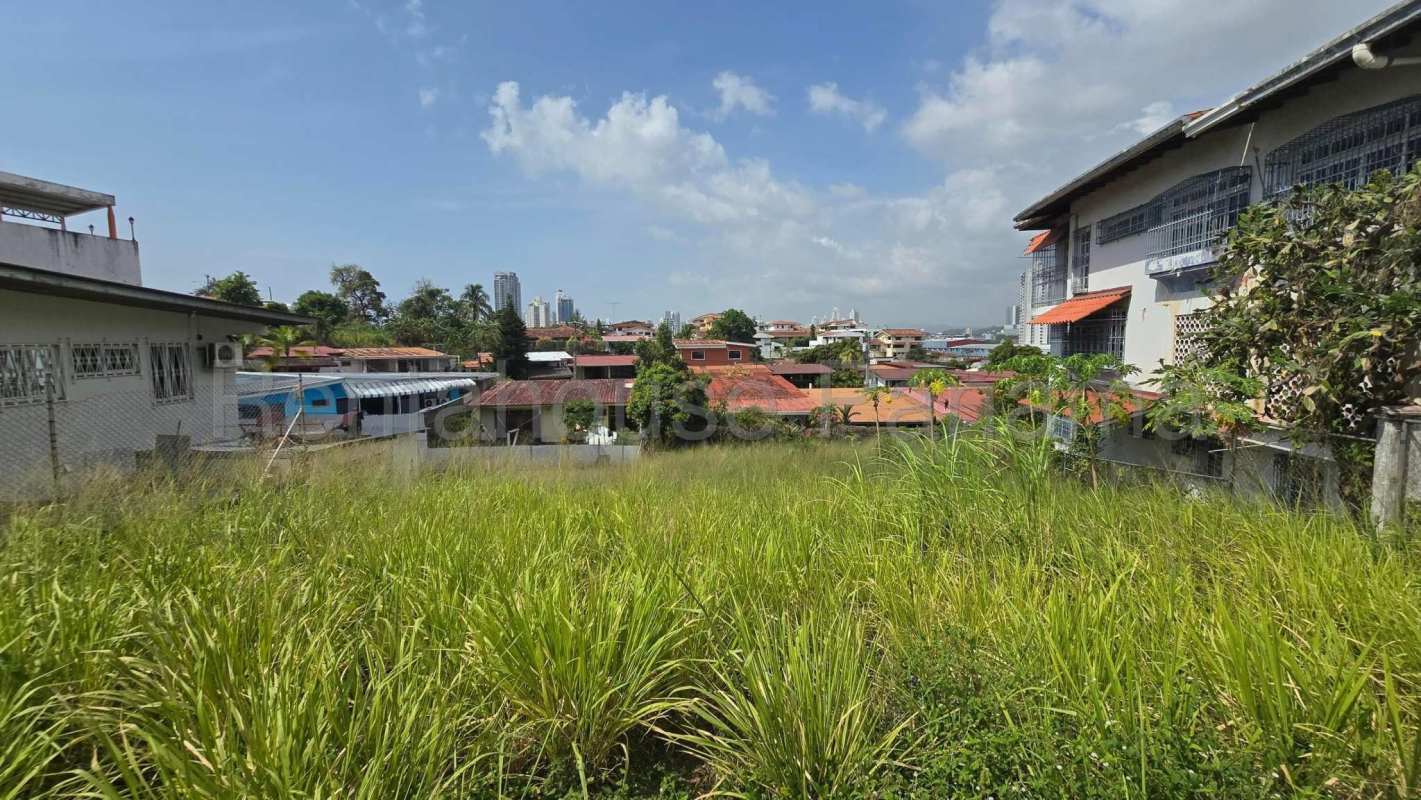 Cleared grassy lot ready for development in Hato Pintado Panama surrounded by houses and city skyline
