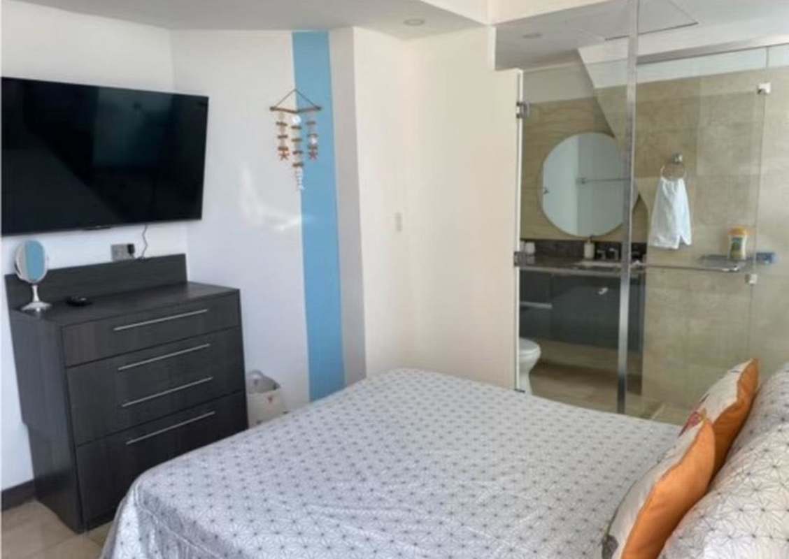 Furnished bedroom with en-suite bath, glass wall and modern touches at JW Marriott Punta Pacifica Panama