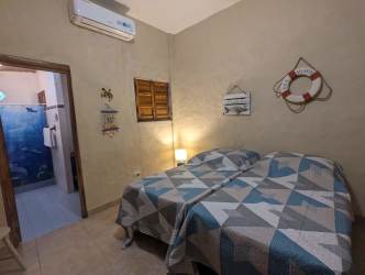 Coastal themed bedroom with turquoise walls, wood ceiling Palenque beachfront villa