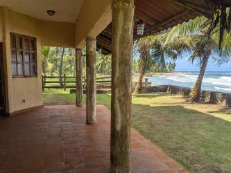 Covered veranda with ocean view and garden at beachfront villa Palenque Panama