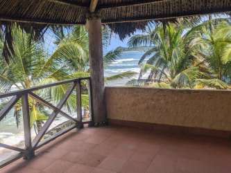 Private beachfront balcony with palm trees and ocean waves Palenque Panama