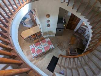 Rustic tropical open plan living dining with curved staircase Palenque Panama beach house