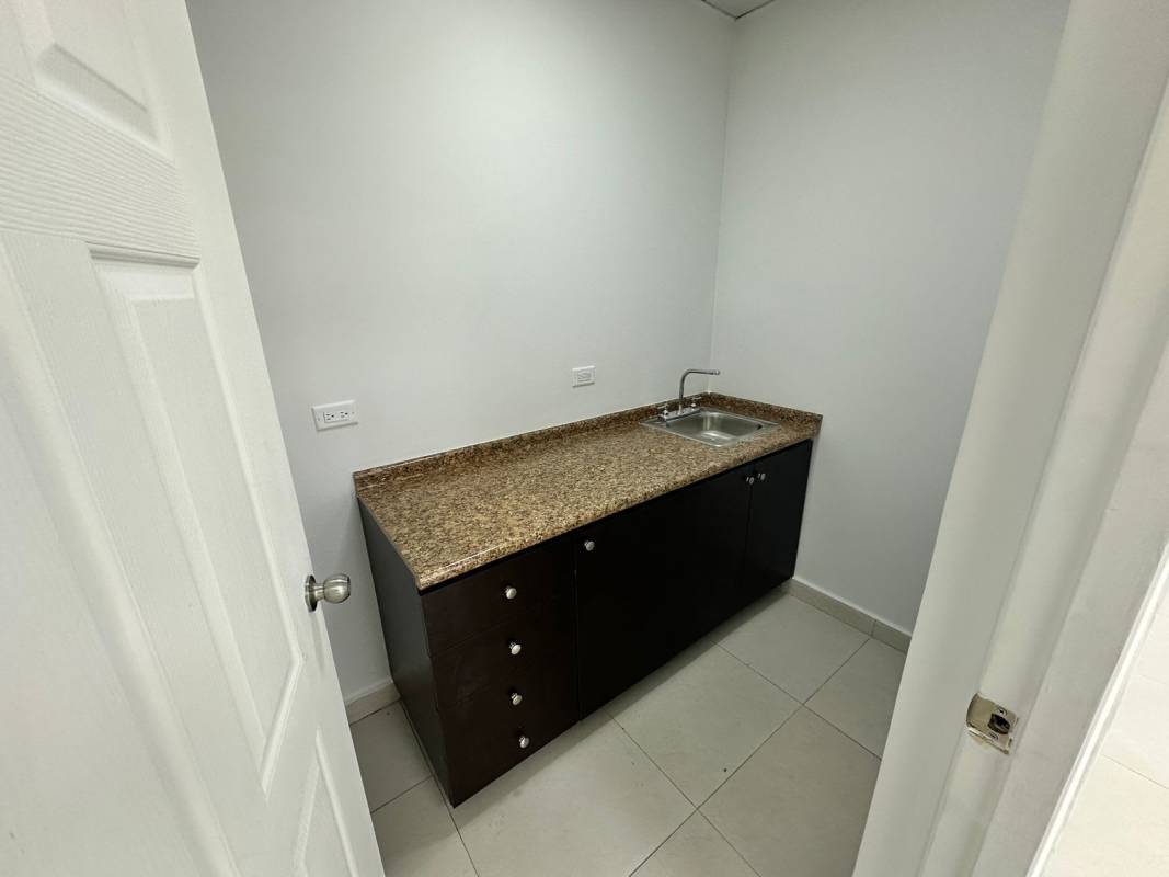 Kitchenette with granite countertop, stainless sink, dark cabinets in Don Bosco retail unit