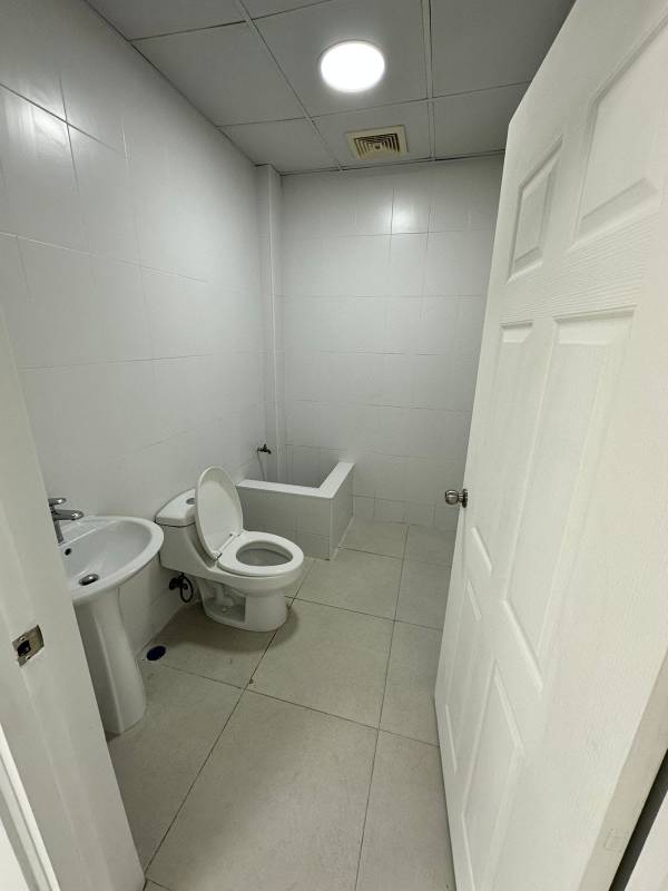 Minimalist white tiled bathroom with toilet and pedestal sink commercial property Panama