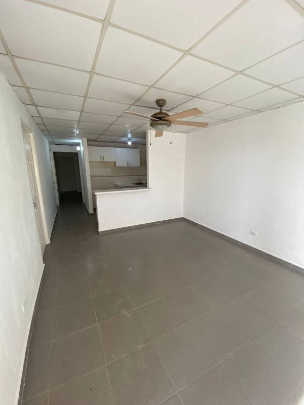 Open plan living and kitchen with tile floors and bright walls in Panama house