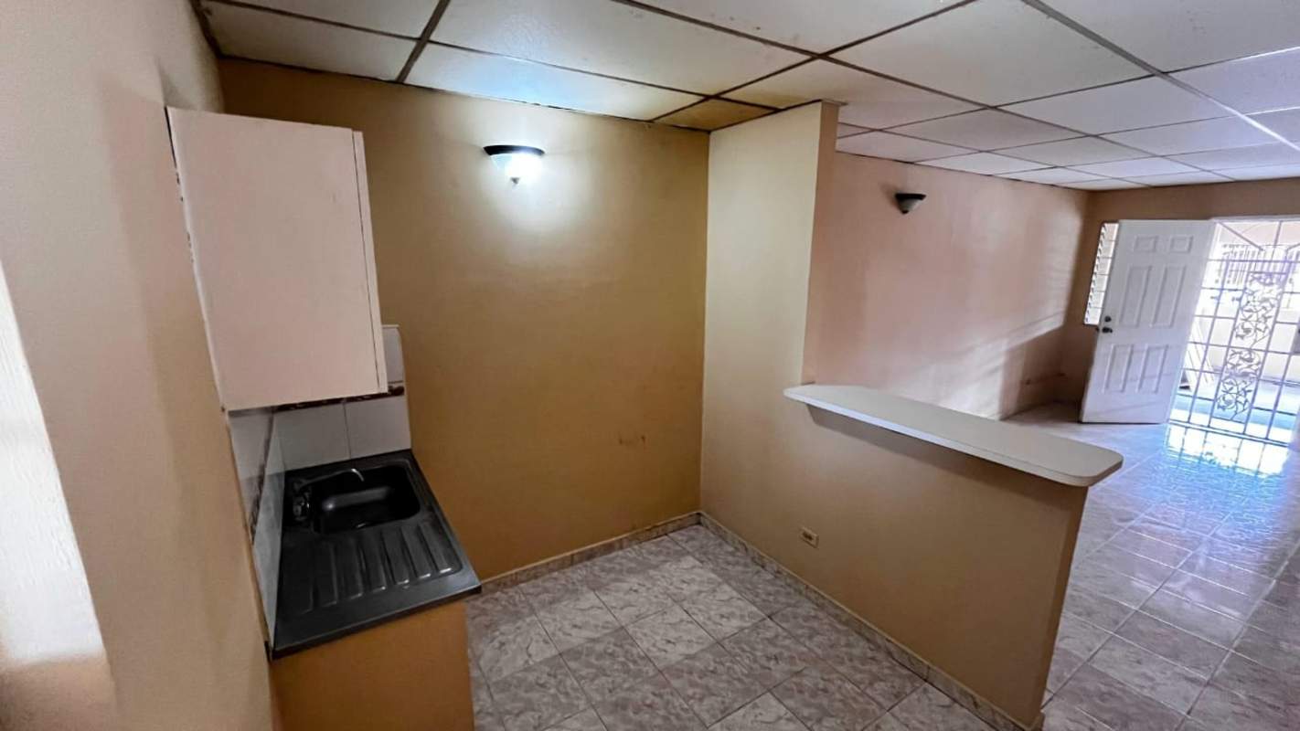 Open interior layout with beige walls, tiled floor, integrated kitchen in Puerta del Este Tocumen